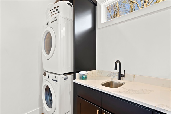 Streamline your chores in style with this chic laundry space, boasting sleek appliances and a fresh, modern vibe.
