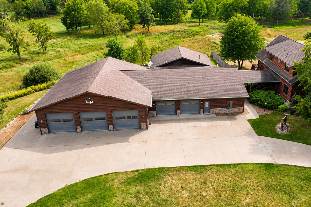 Aerial view of the property entrance, buildings, driveway, and parking area, showing the generous space available for larger groups traveling with multiple vehicles and outdoor gear.
