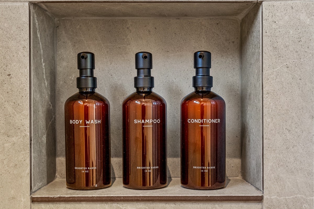 Guesthouse shower stocked with quality shampoo, conditioner, and body wash for a comfortable, hotel-style stay.