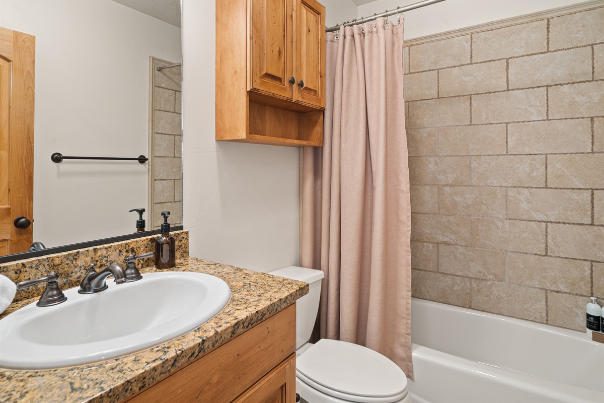 Full bathroom with granite vanity and tub/shower combo