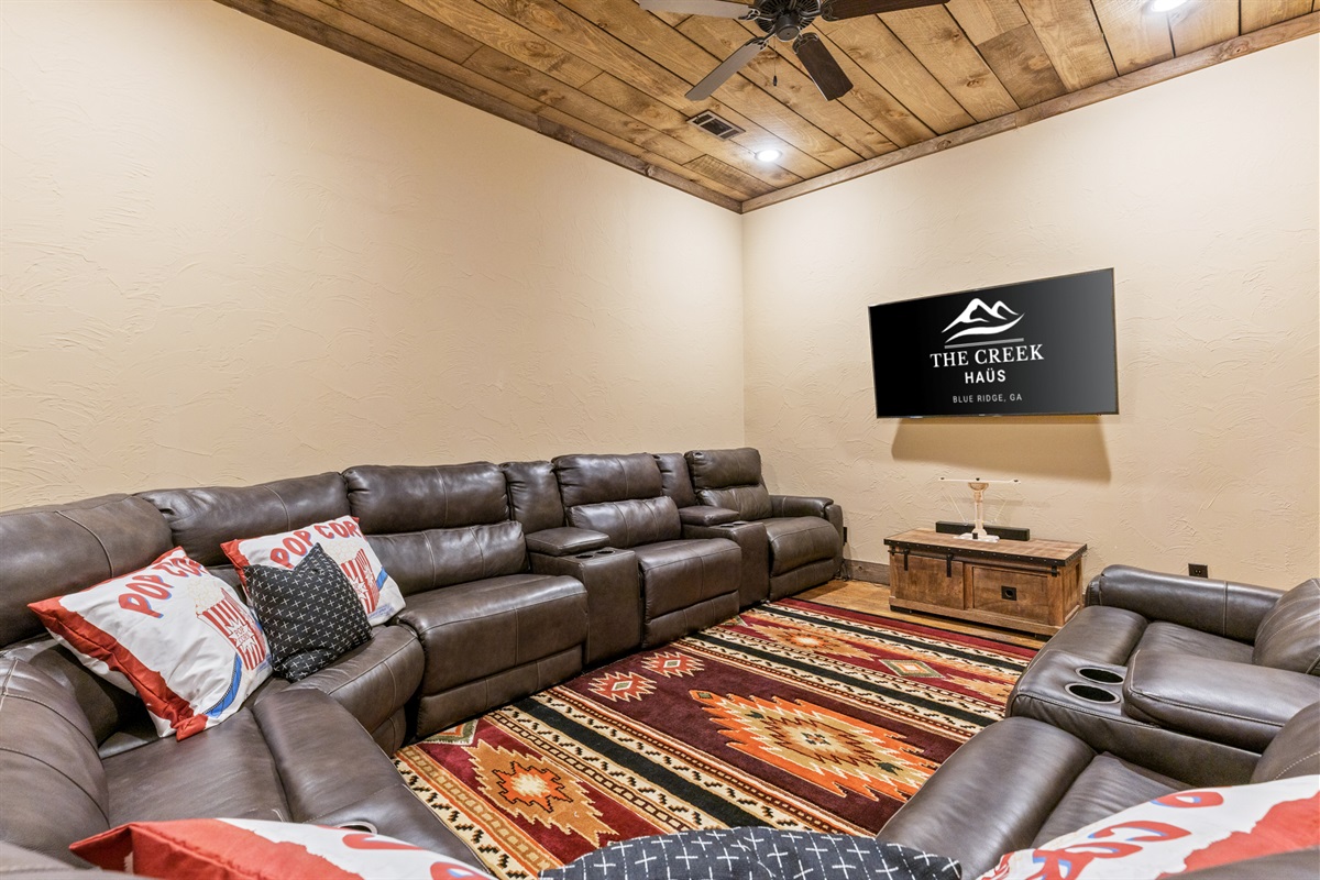 The movie room is the ultimate spot to kick back, featuring oversized seating and a big-screen TV for movie marathons or game days.