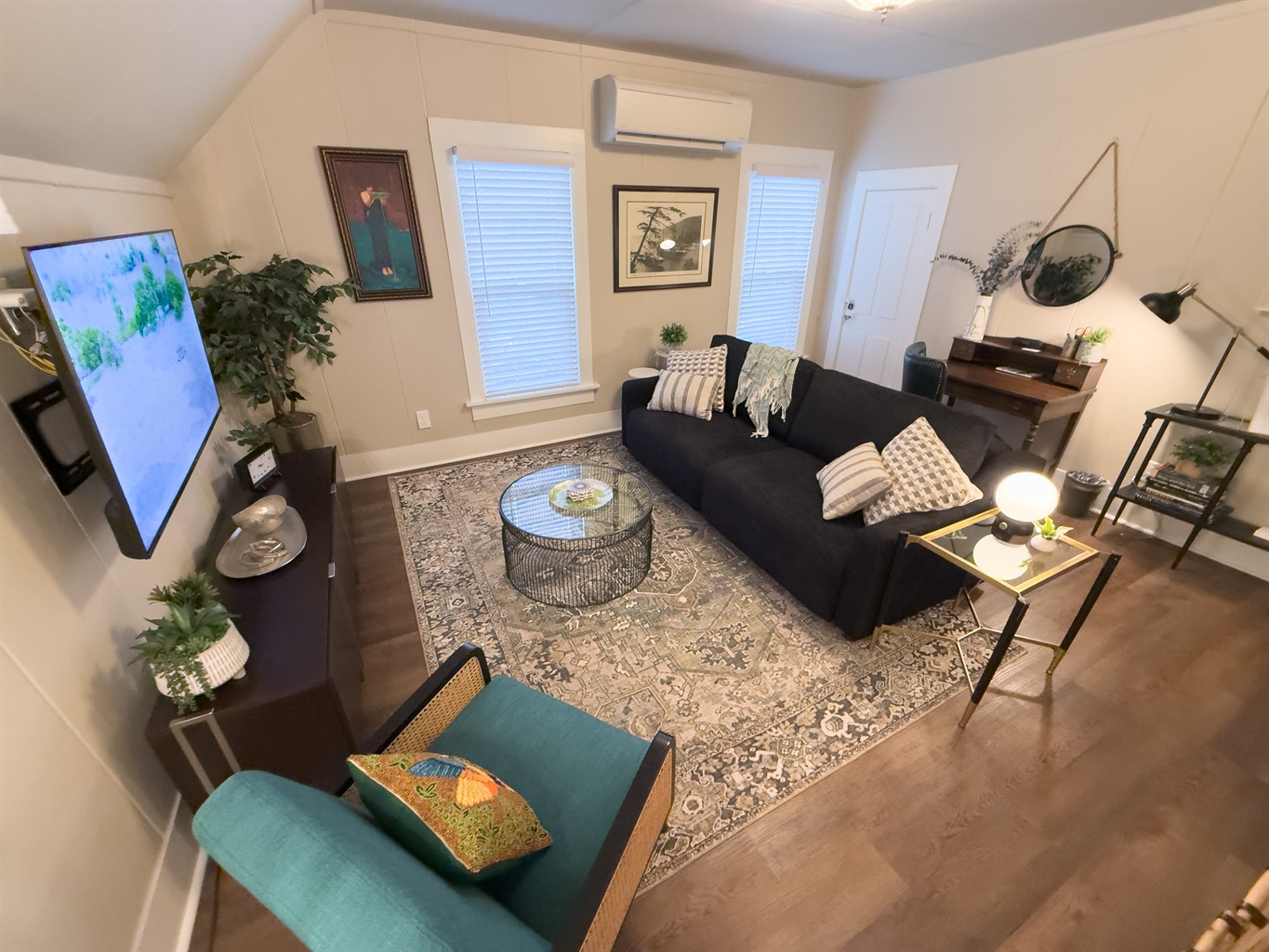 Living room with SmartTV, queen sofabed, desk, and games.