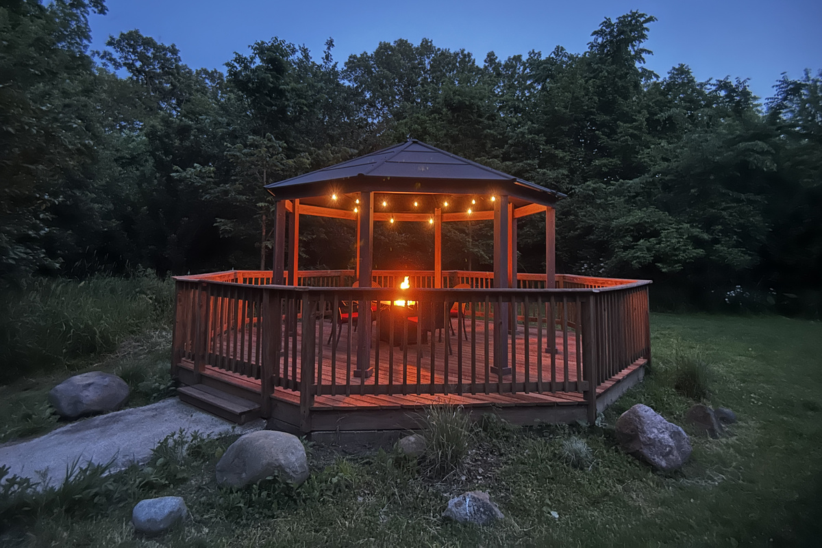 The gazebo is a shared space where you can relax under the cafe lights by the fire table.