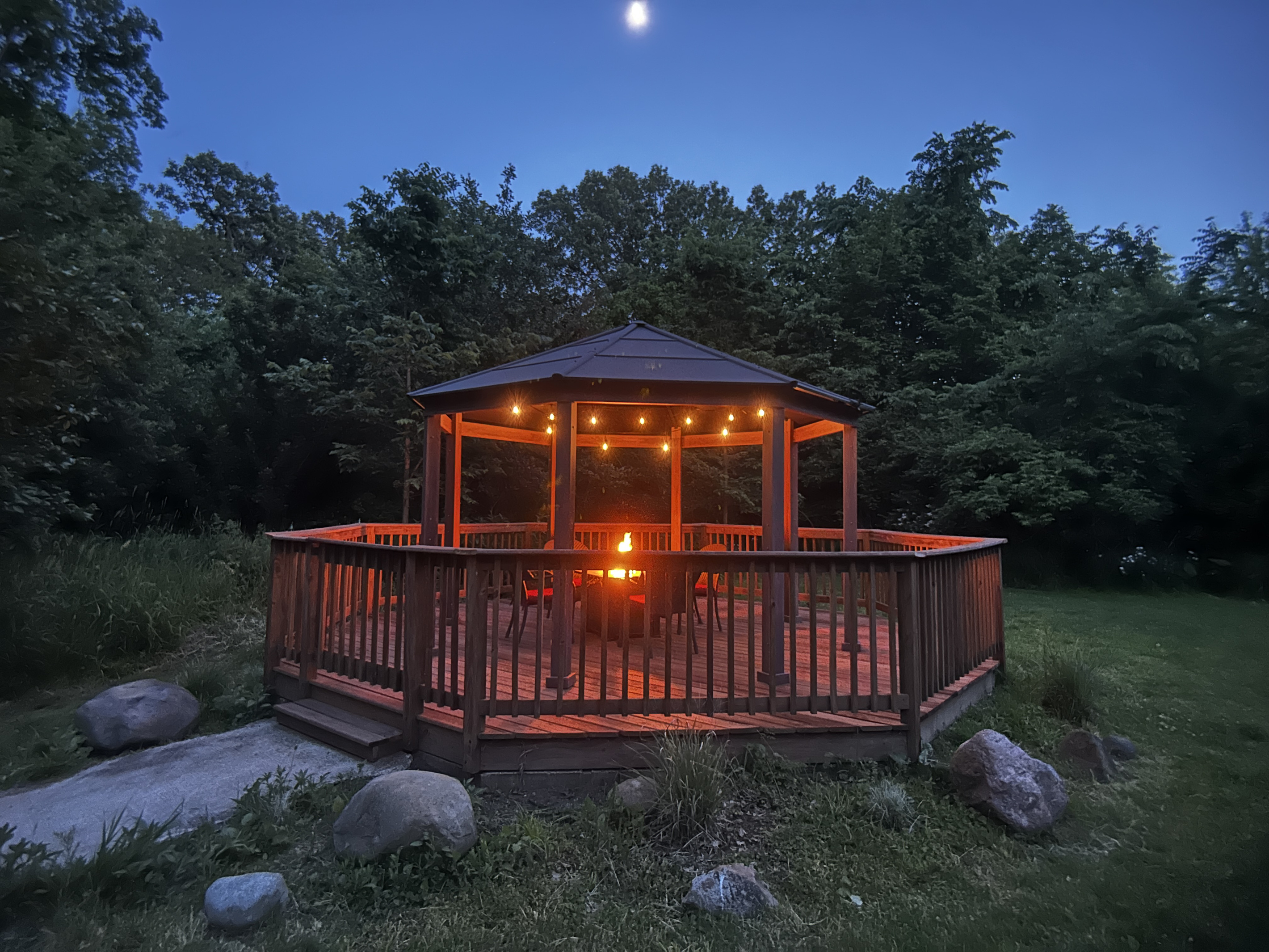 The gazebo is a shared space where you can relax under the cafe lights by the fire table.