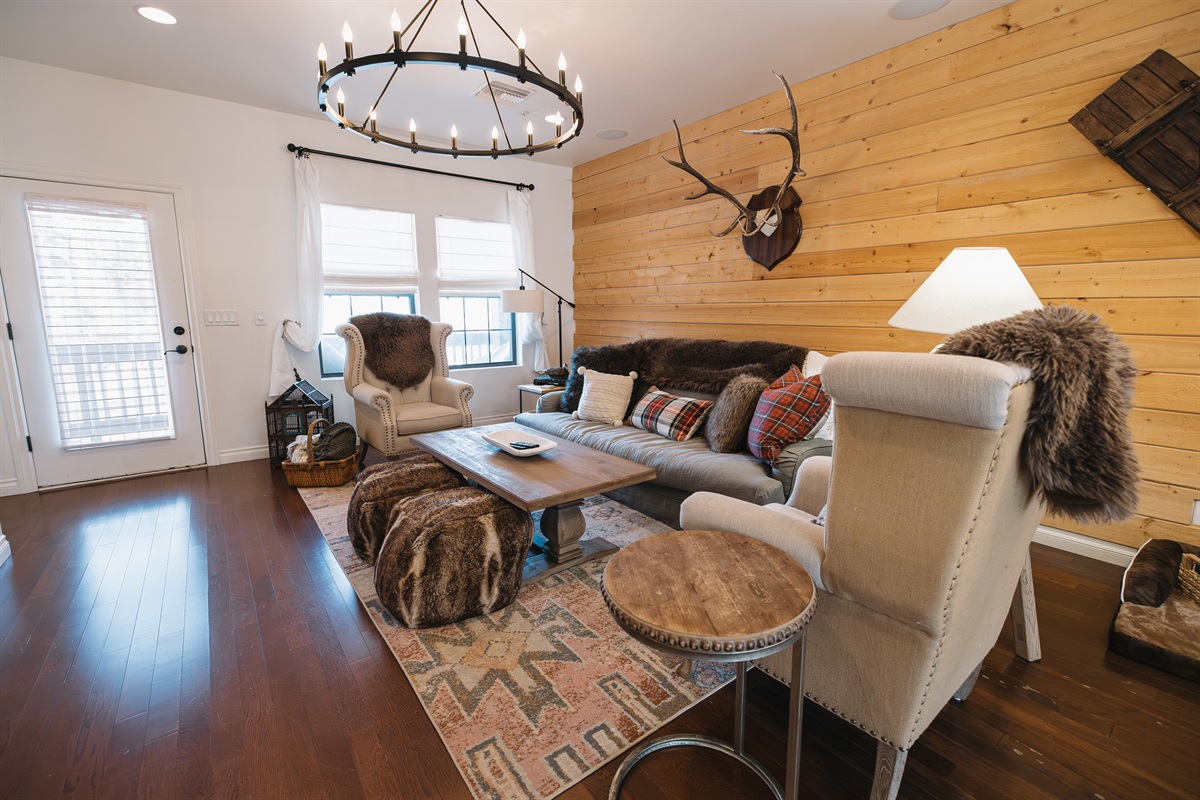 Warm, inviting living room with mountain-lodge style, plush seating, wood accent wall, and cozy lighting—perfect for couples or families to relax after days exploring Pinetop and the White Mountains.