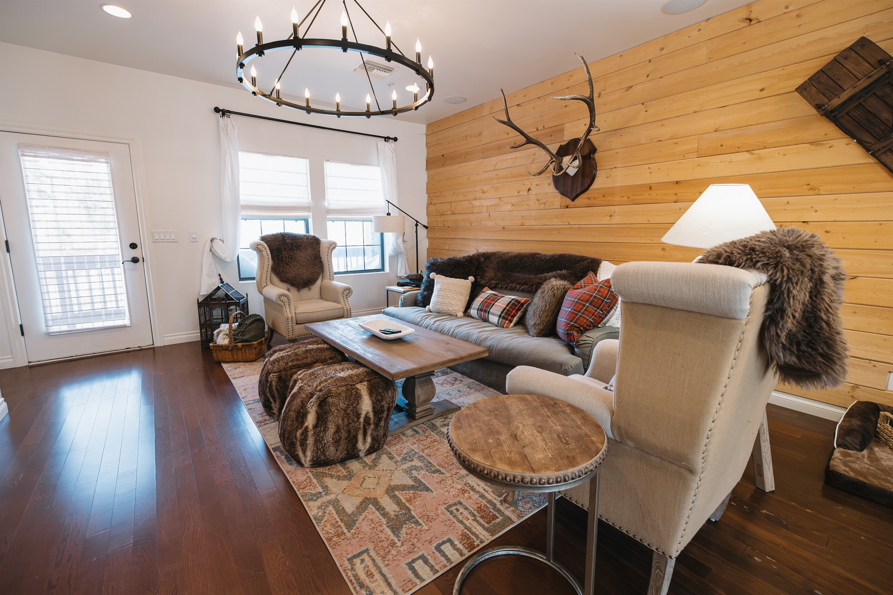 Warm, inviting living room with mountain-lodge style, plush seating, wood accent wall, and cozy lighting—perfect for couples or families to relax after days exploring Pinetop and the White Mountains.