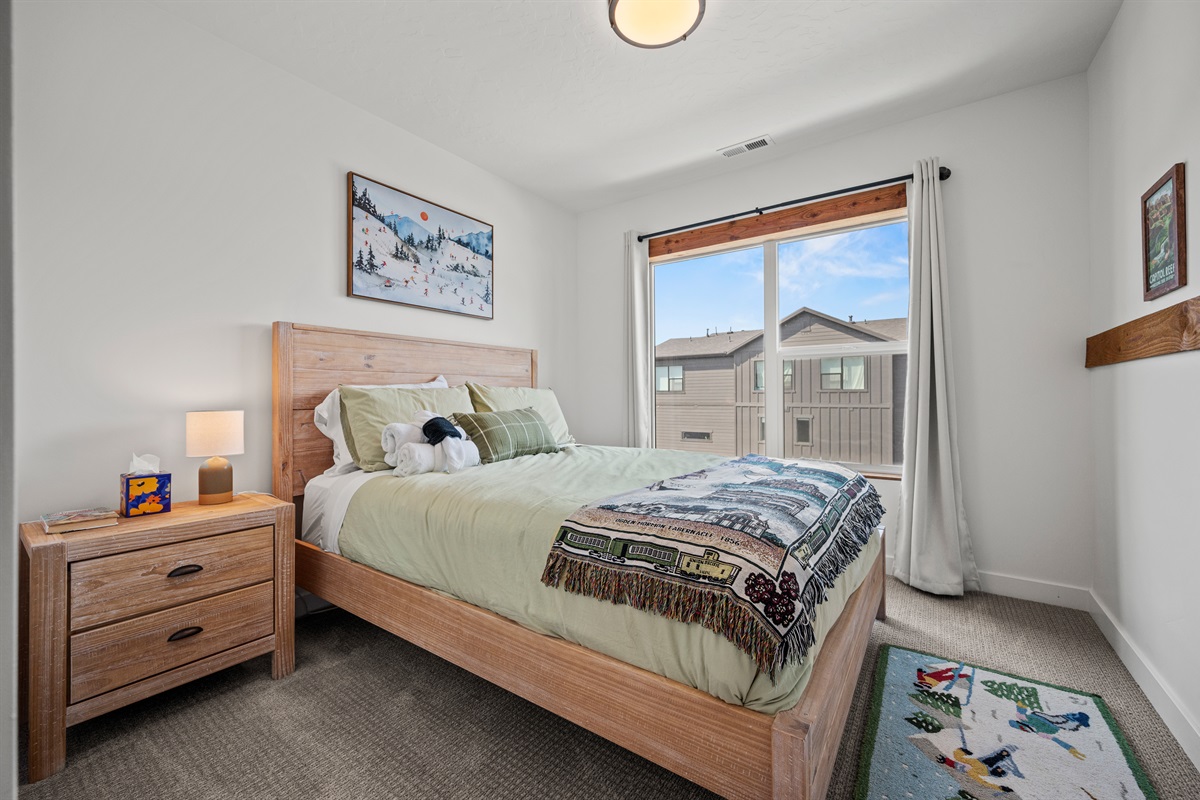 The third bedroom is outfitted with a queen bed, luxurious linens, and plush pillows.