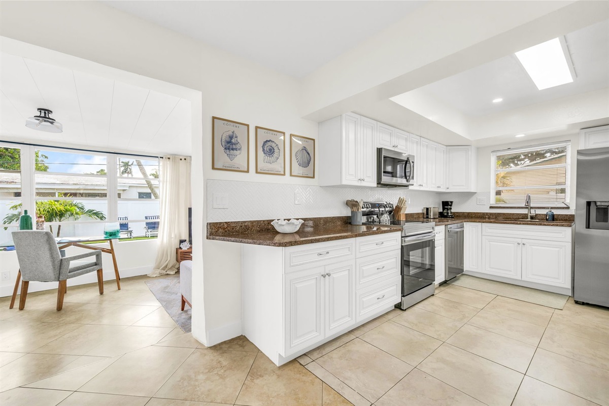 A spacious, light-filled kitchen offering stainless steel appliances, rich countertops, extensive cabinetry, and thoughtful amenities such as a coffee maker, blender, and toaster for effortless cooking and entertaining.