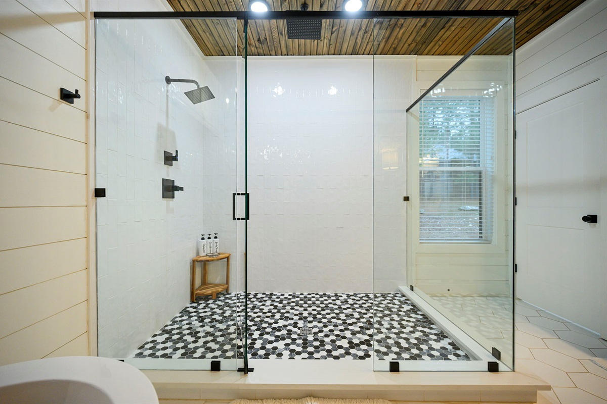 Luxury walk-in shower with custom tile and rain-style head.