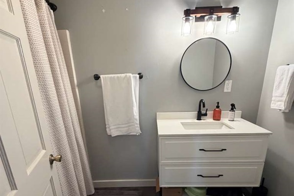 Clean and modern full bathroom with a tub/shower combo, fresh towels, and essential amenities.