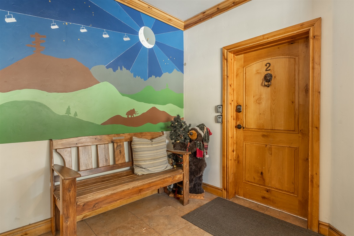 A welcoming entry with a playful mural, custom wood door, and bench—setting the tone the moment you arrive.