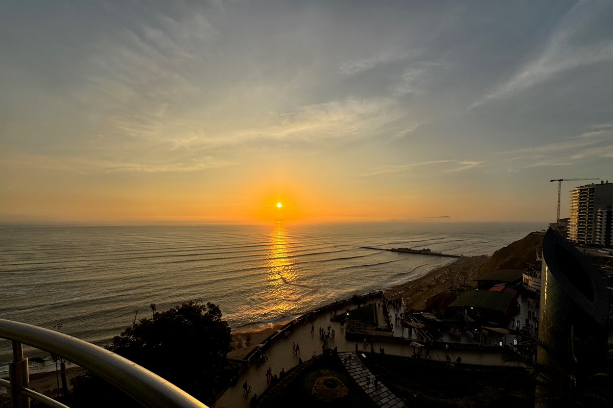 (Photo taken from apartment) View from the living room at evening. World-Class Sunsets: Your private front-row seat to the most magical golden hours in Lima, right from your unique curved balcony