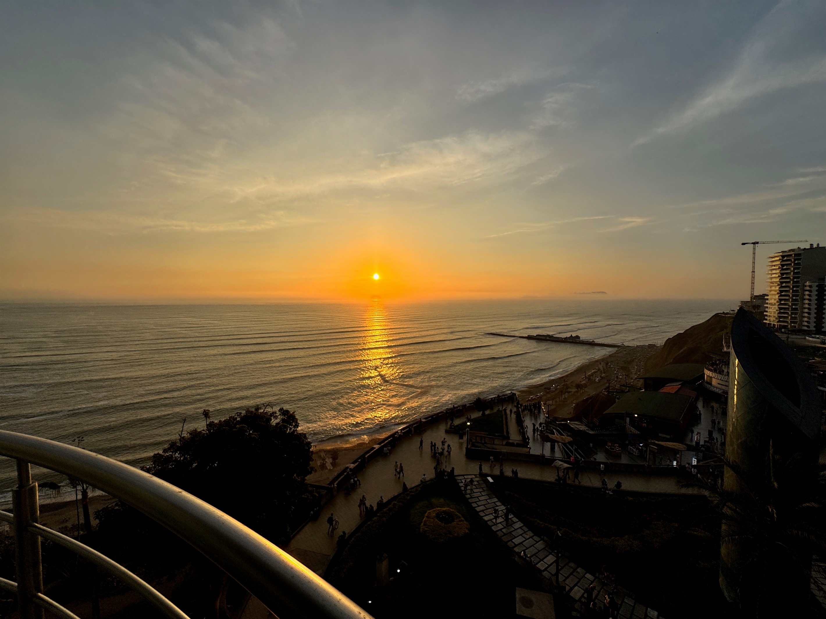 (Photo taken from apartment) View from the living room at evening. World-Class Sunsets: Your private front-row seat to the most magical golden hours in Lima, right from your unique curved balcony