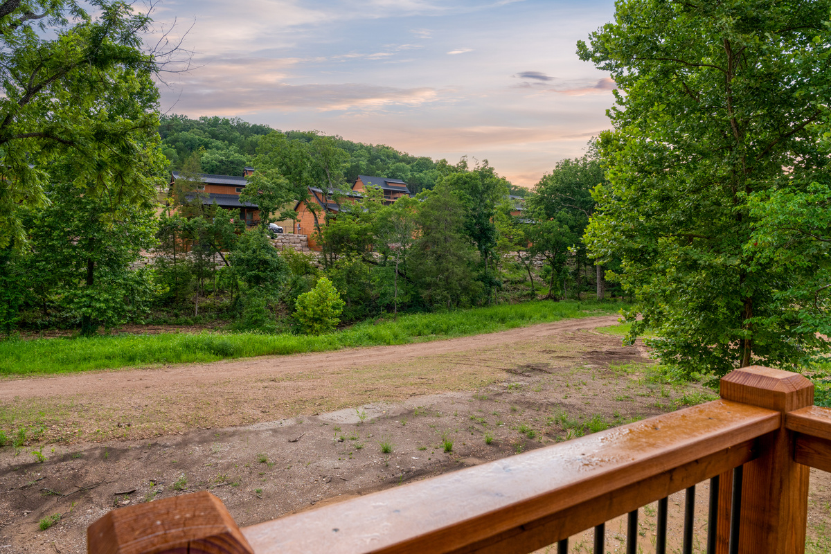 Look out over quiet Ozark woods and neighboring cabins as the sun dips low.