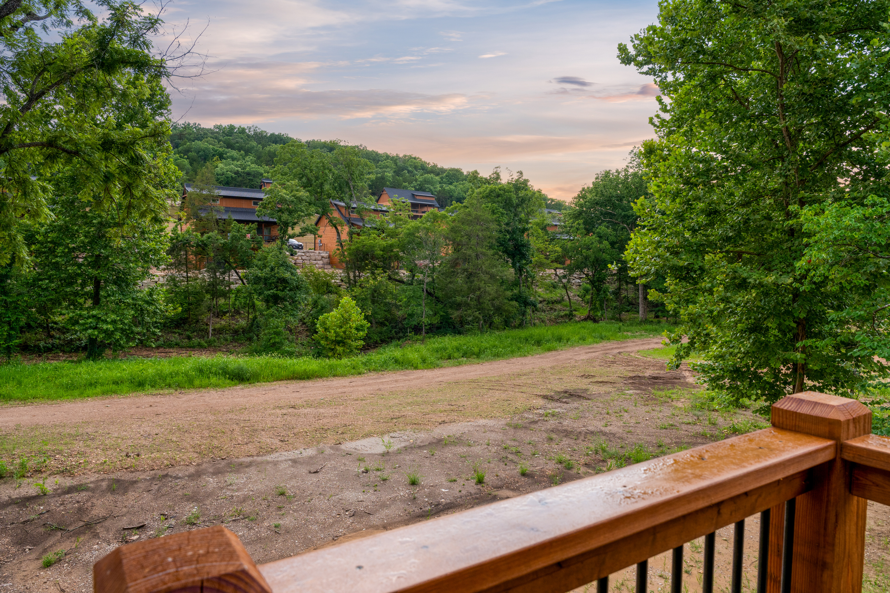 Look out over quiet Ozark woods and neighboring cabins as the sun dips low.