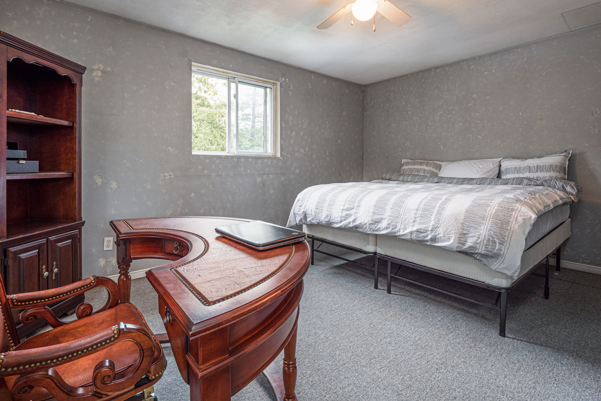 Comfortable bedroom with dresser and natural light