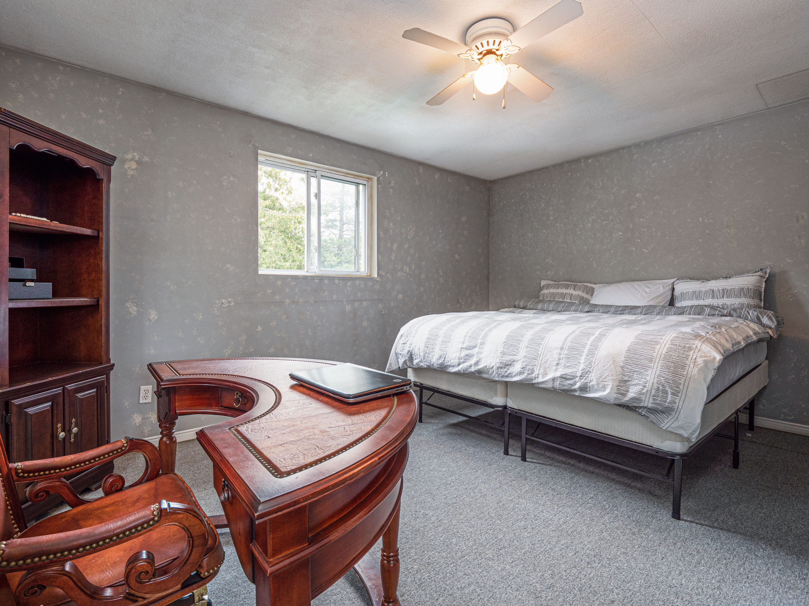 Comfortable bedroom with dresser and natural light