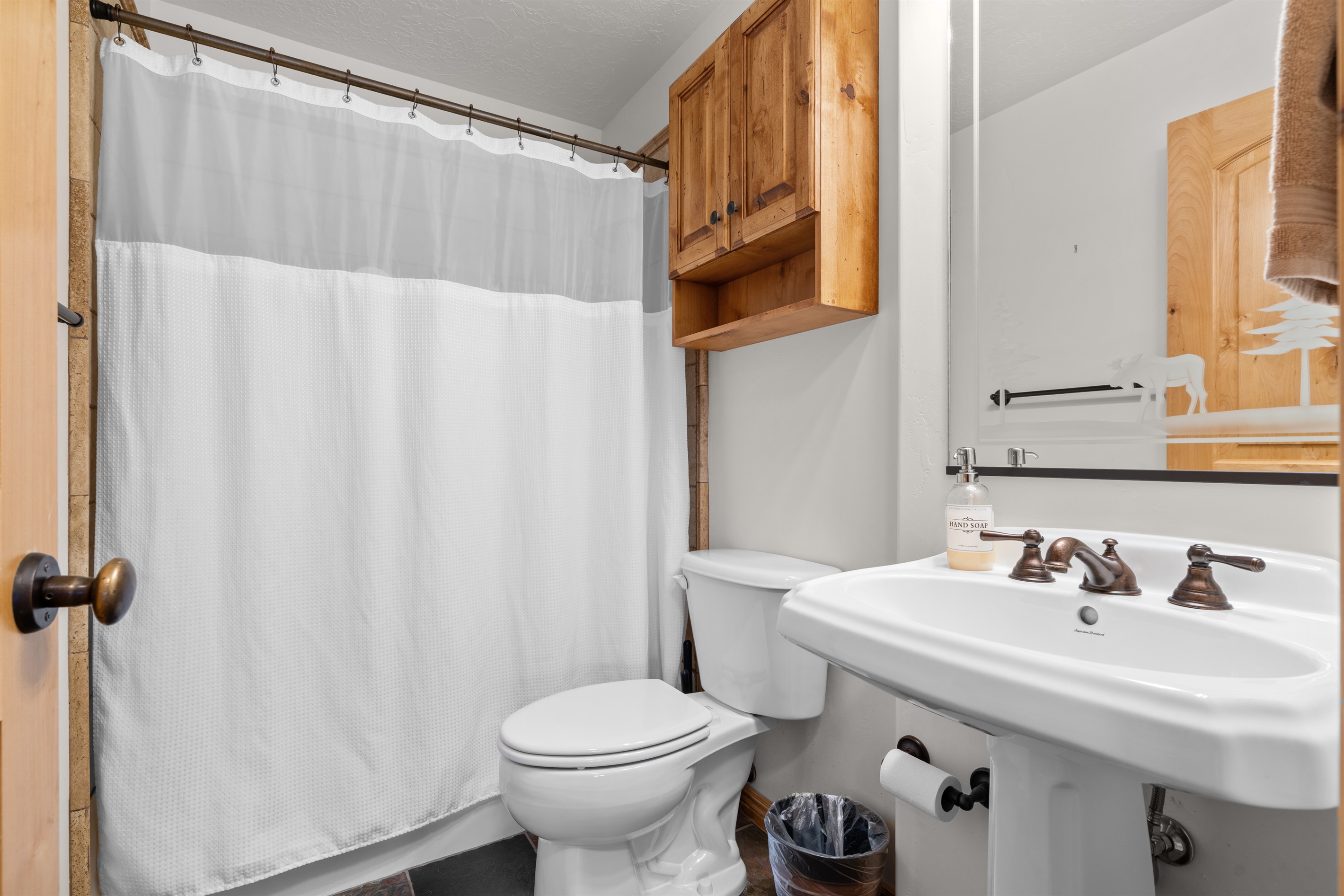 The second bathroom has a combined shower and bathtub.