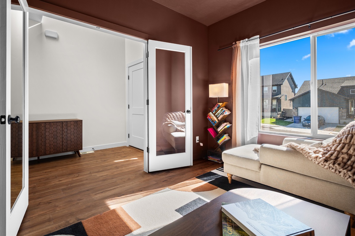 Inviting main-level den with elegant decor and bright windows creating a calm, comfortable retreat.