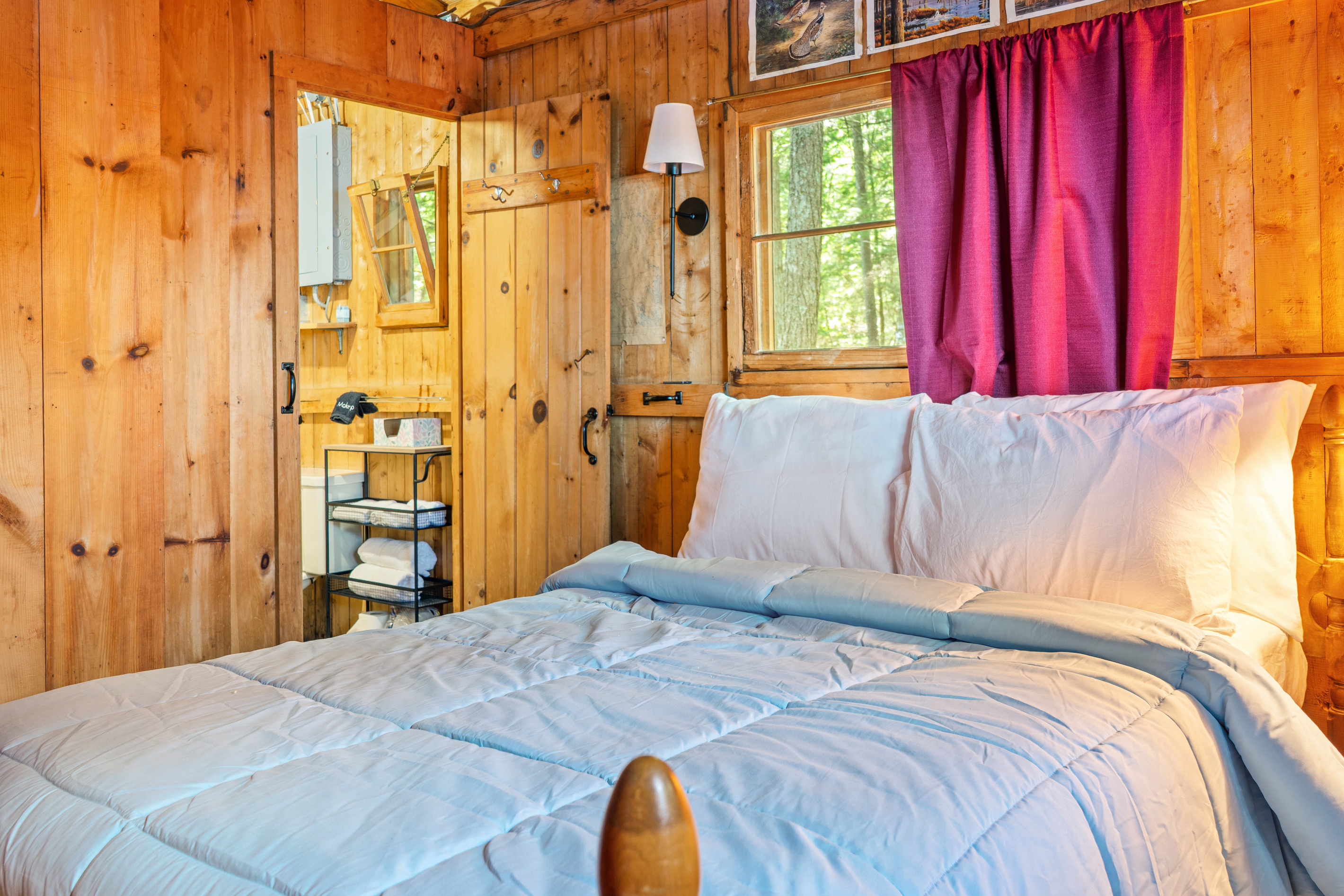 Layout note at Loonrise Point: This bedroom provides access to the camp's only bathroom (visible here). Classic, cozy Maine camp layout where guests pass through to reach facilities—ideal for close families on Beech Hill Pond in Otis, ME.