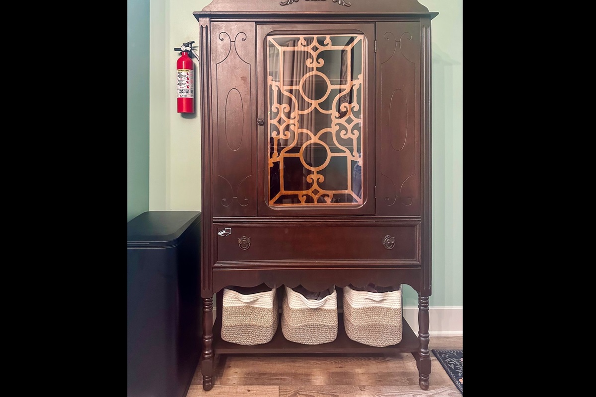 Pantry cabinet offering additional storage alongside a conveniently placed trash receptacle to keep the kitchen organized.