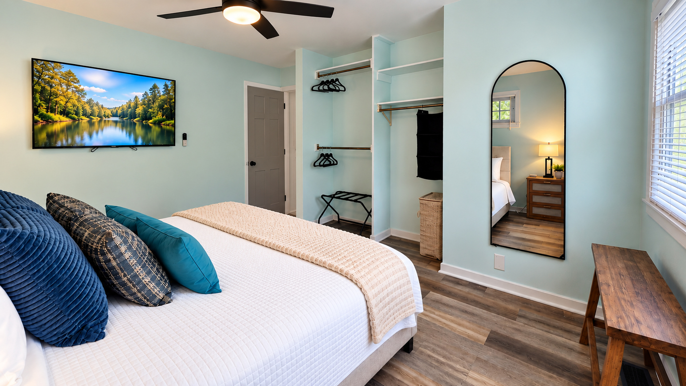Spacious king bedroom with Smart TV, full-length mirror, open closets, luggage rack & bench.