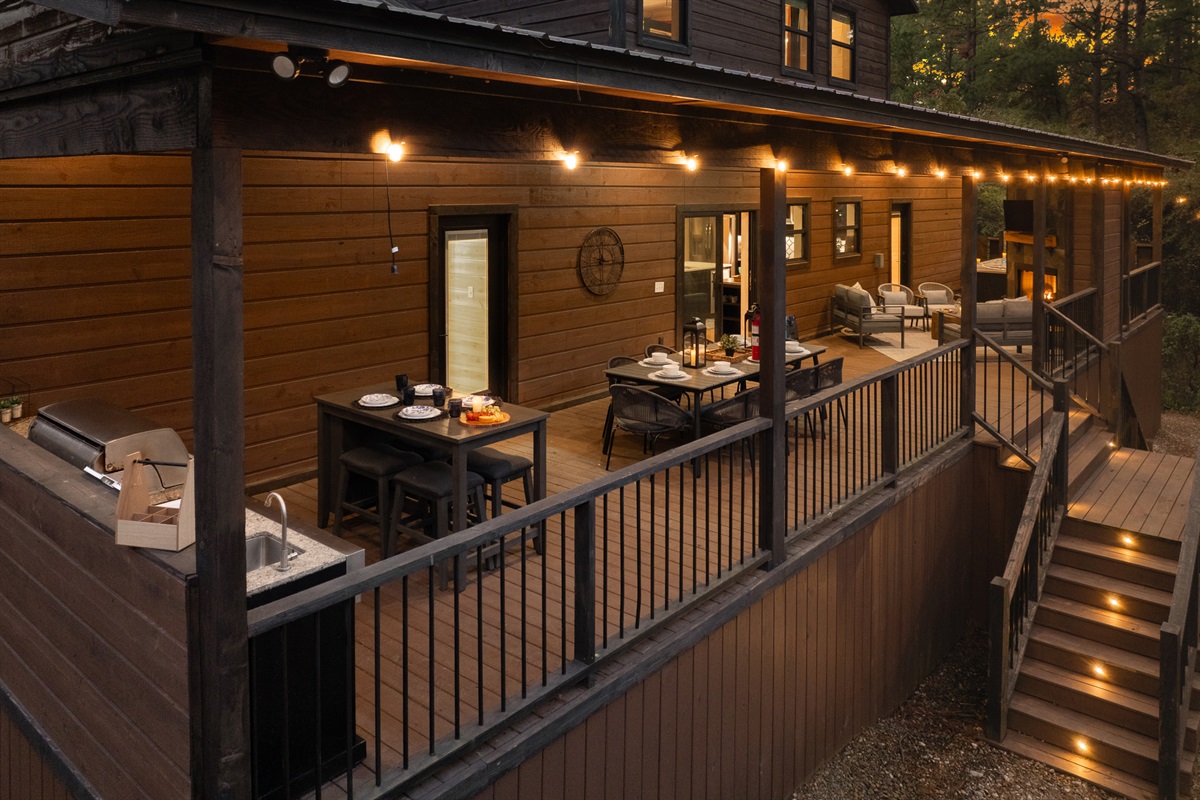 Spacious covered deck with a full dining table and easy indoor access, perfect for lingering meals that flow from kitchen to forest.