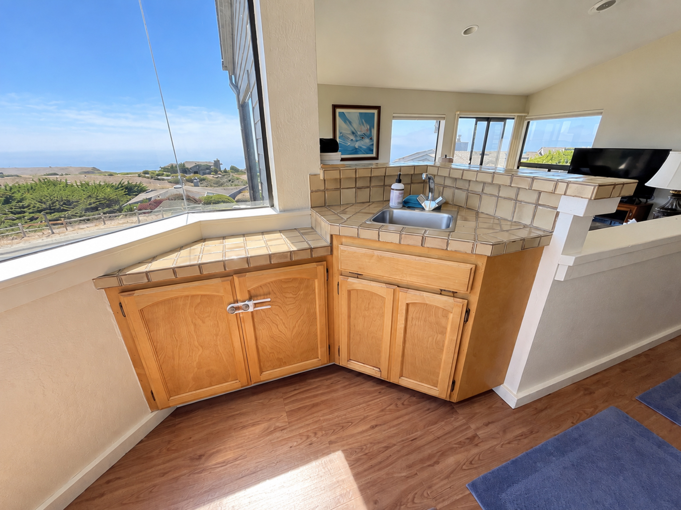 Bar sink area with cabinet full of wine, champagne, drink ware.