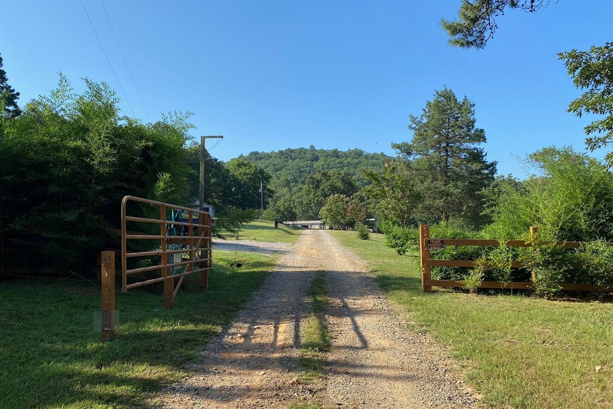 Entrance gate. Farmhouse is at the end of the road on the left.  Bald Mountain in the background.