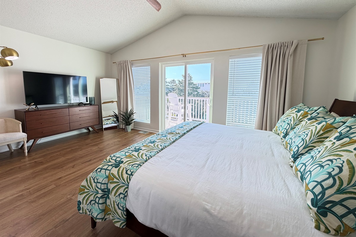 The primary bedroom provides a private balcony with a view.