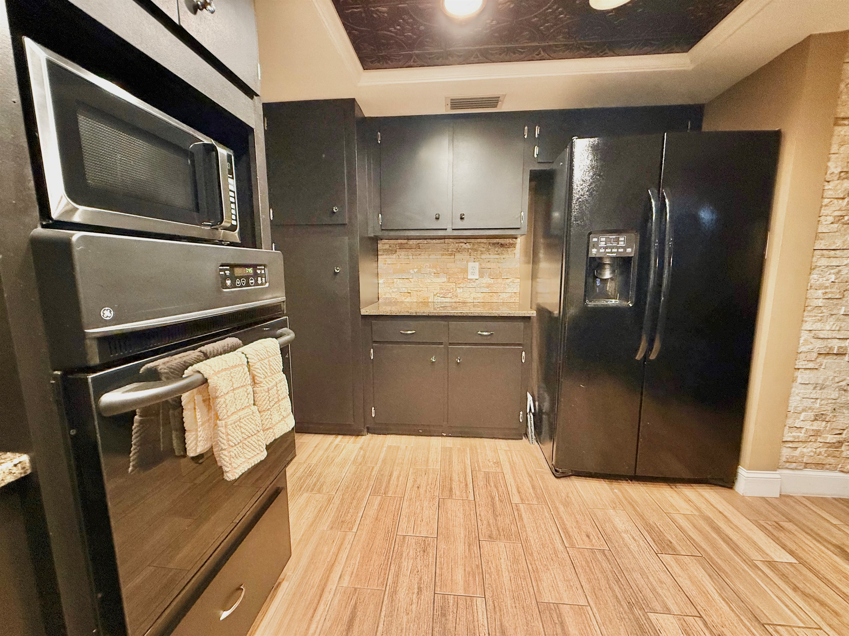 You'll love the layout that offers generous counter space, plenty of storage, and a full suite of stainless and black appliances to meet all your culinary needs.