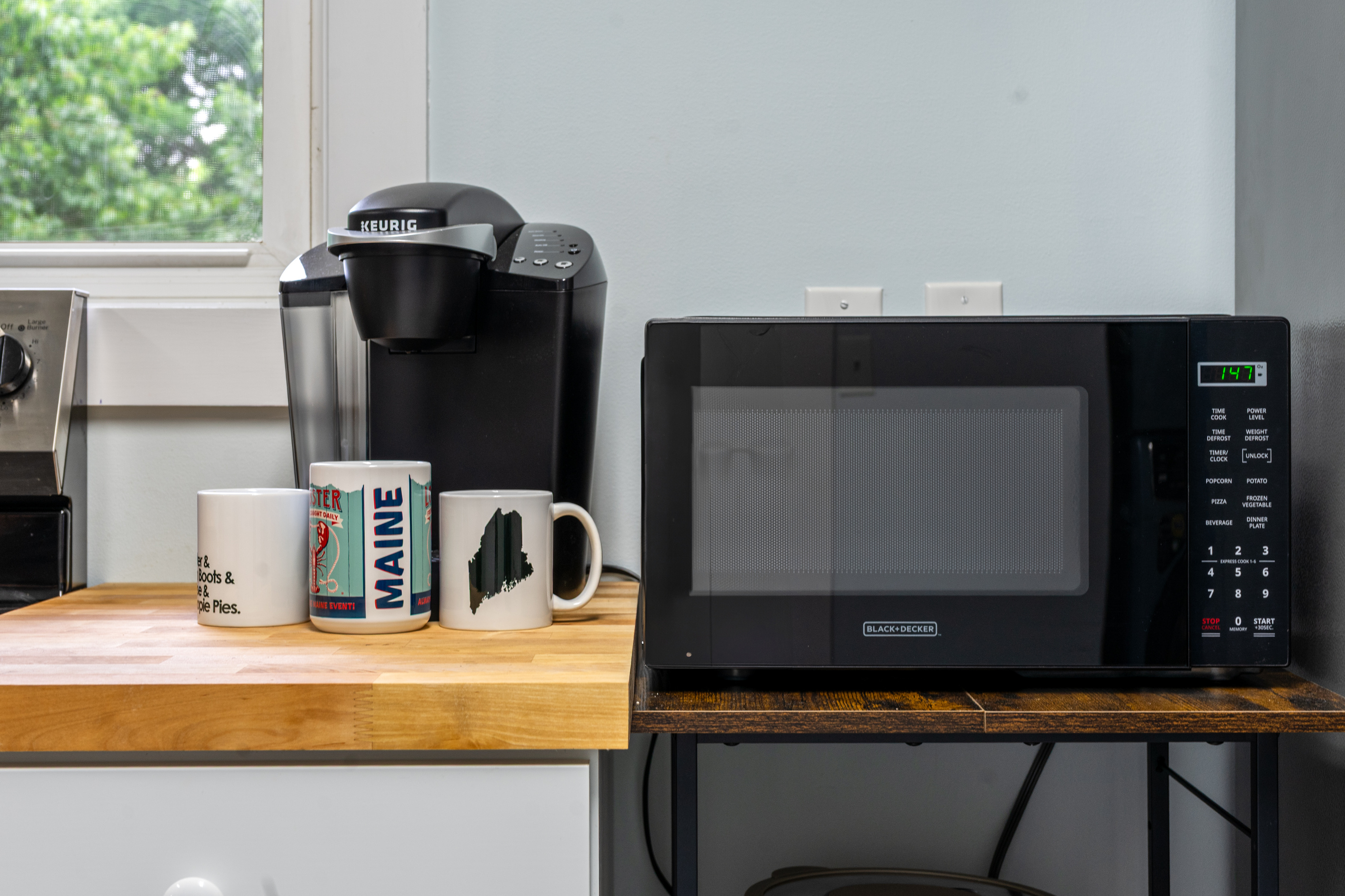 Start your morning by brewing a fresh cup with the Keurig coffee machine, or use the convenient Black+Decker microwave for quick meal prep. This cozy corner keeps your daily essentials organized and ready for any Downeast Maine adventure.