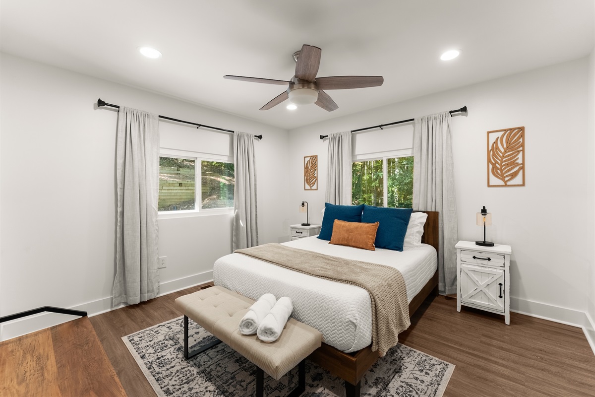 Second bedroom upstairs with queen bed and flat-screen TV.