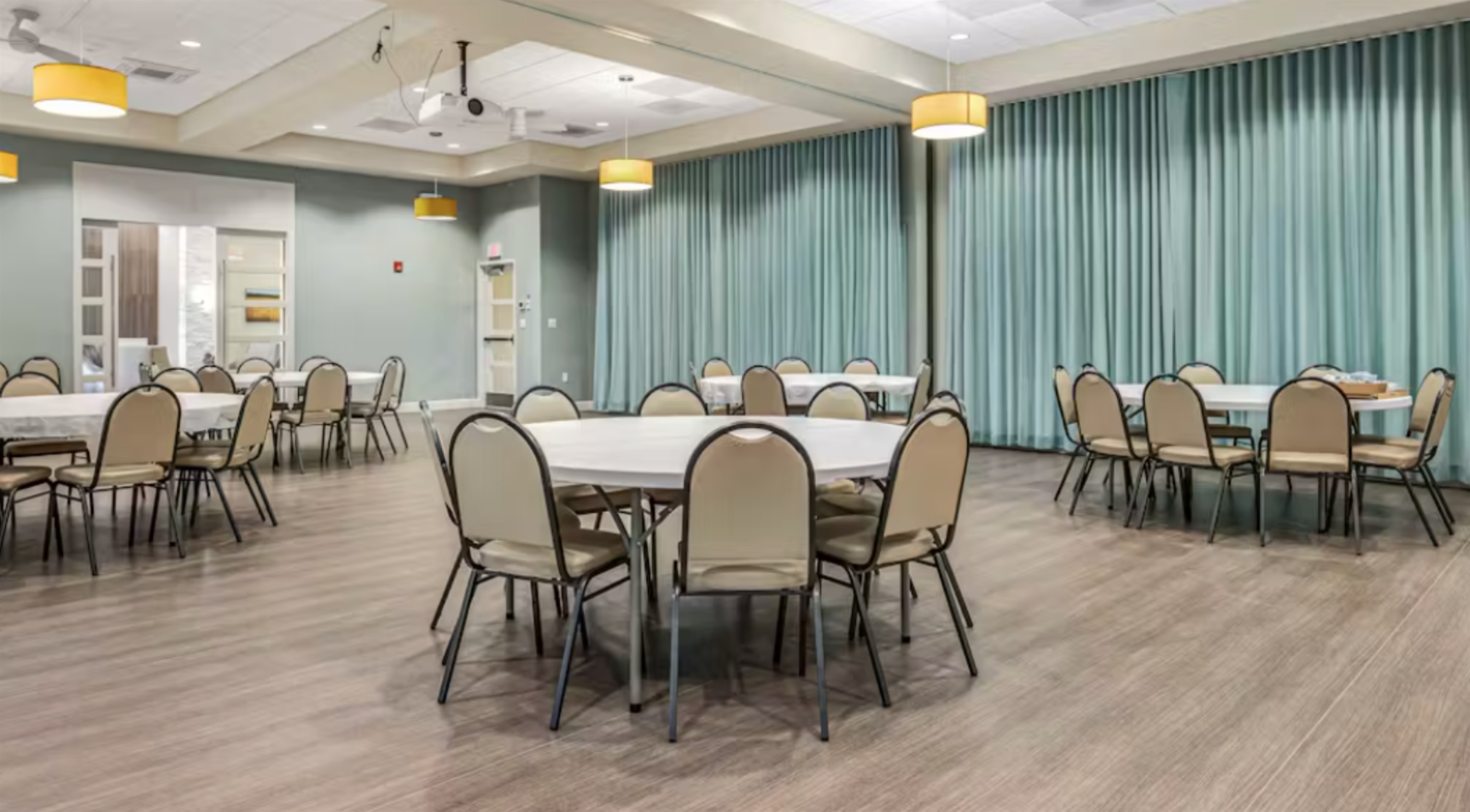 Versatile Event Hall: Host birthday parties, workshops, or group dinners in a spacious, flexible room with round tables and seating to suit any occasion.