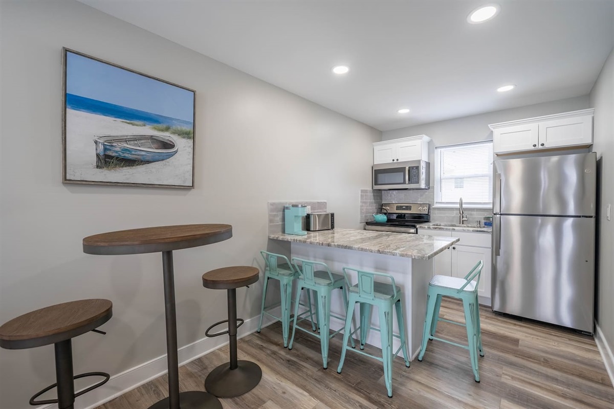 Bright kitchen and dining area with stainless steel appliances, ample counter space, and a breakfast bar with seating. The open layout makes it easy to prepare meals, enjoy casual dining, or gather comfortably throughout the day.