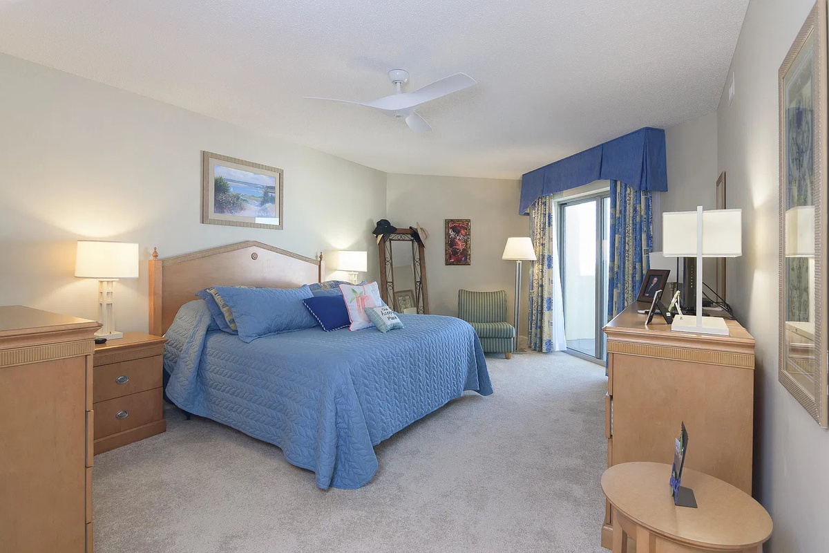 Spacious main bedroom with king bed, balcony access and ensuite