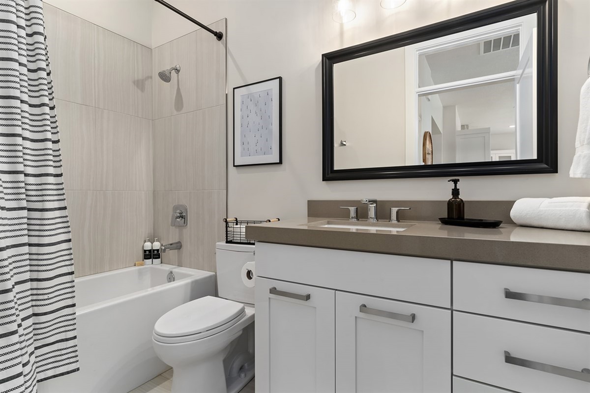 Full bathroom with tub/shower combo and clean, modern design.