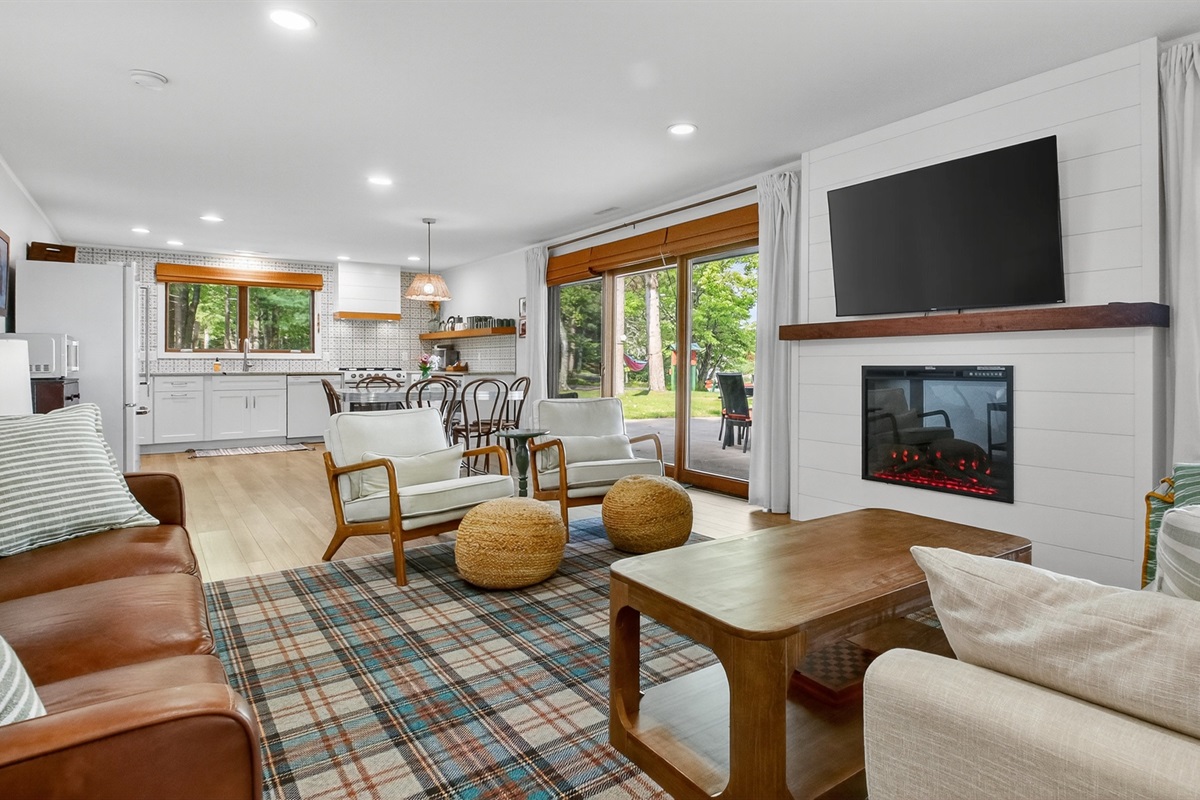 Cozy up in the bright, open living room with comfortable seating, fireplace, Roku TV, and big windows that frame the lake.