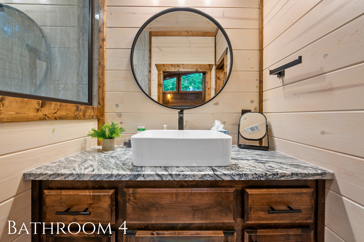 Elegant and modern, this bathroom features a chic round mirror and rustic touches that elevate your routine.
