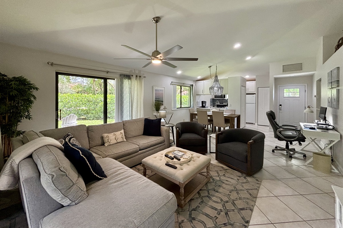 Our large, open living room has seating for six in front of the TV. Two large sliding glass doors let in plenty of light and views of the surrounding, peaceful landscaping.