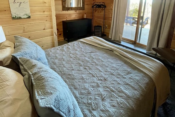 Basement bedroom has a queen bed and steps out to the lower patio with a bench swing and infrared sauna!