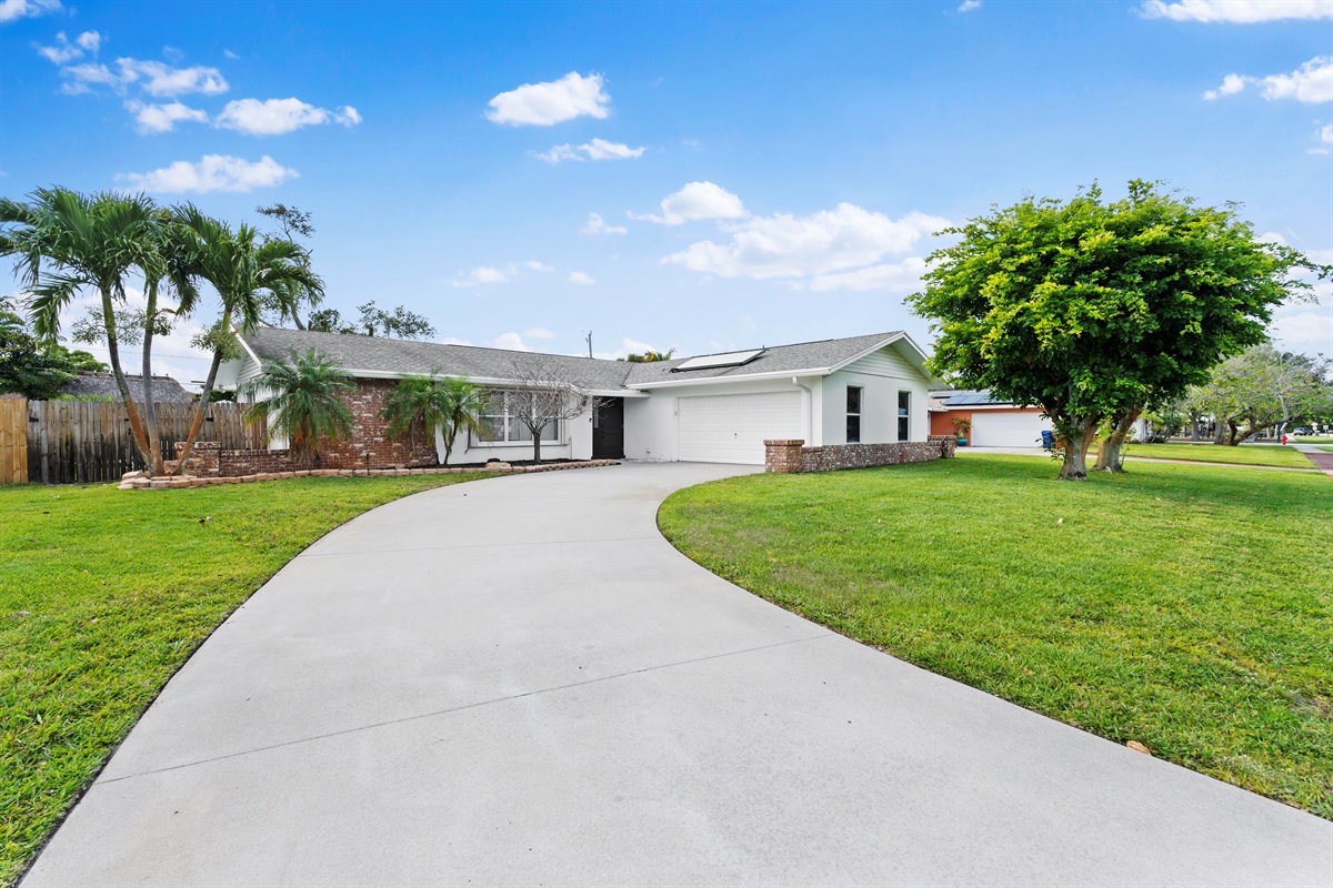 A grand curved driveway and lush surroundings create a warm welcome from the moment you arrive.