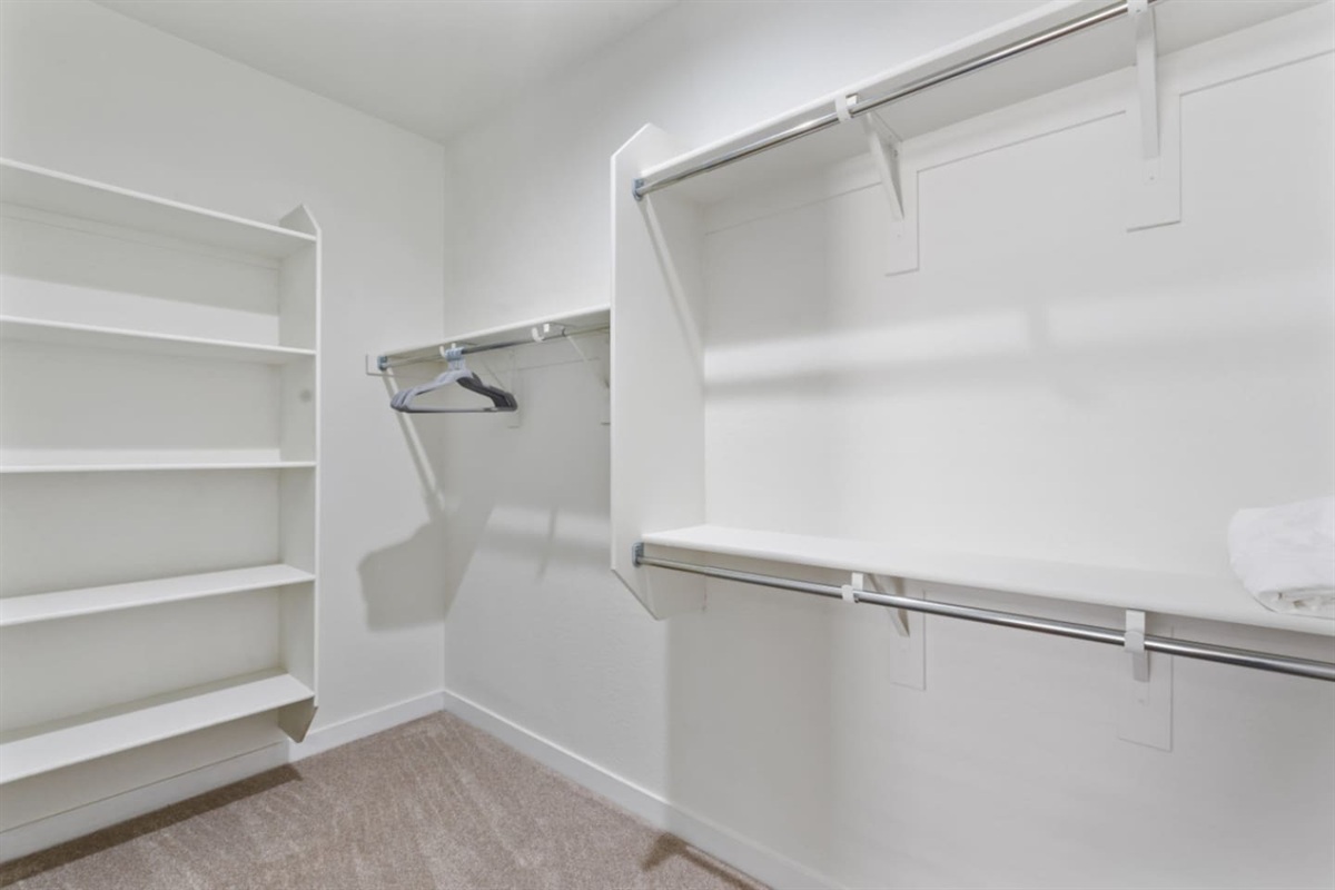 Walk-in closet with open shelving, hanging space, and room to unpack for short or extended stays.