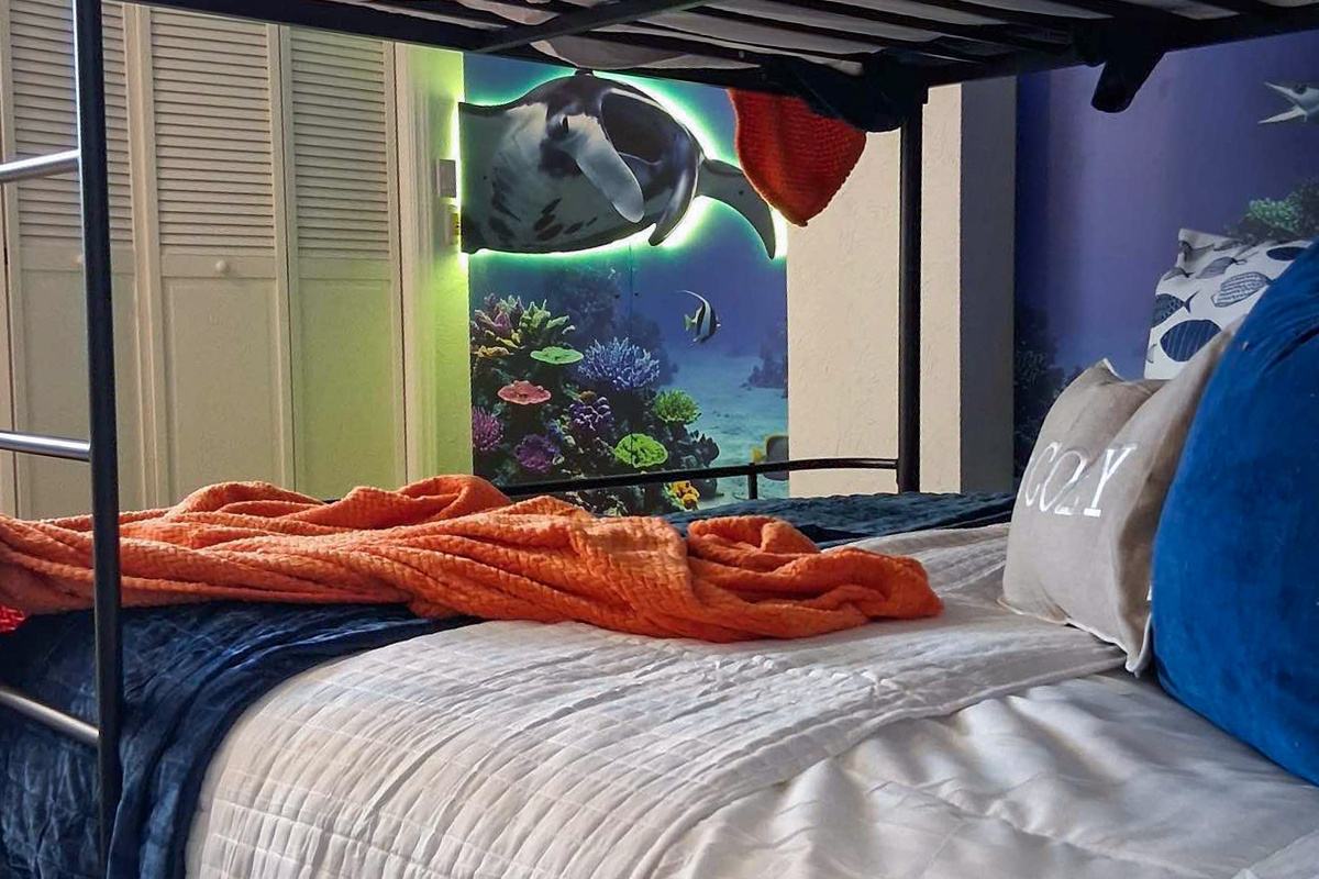 The fourth bedroom is the Aquarium room, including queen bunk beds and twin bunk beds, sleeping up to 6 people comfortably.
