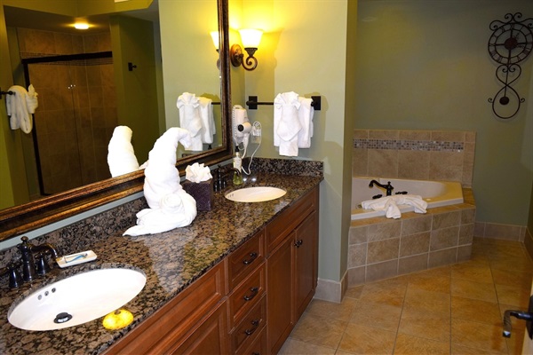 Spacious Primary Bathroom featuring granite vanity, large whirlpool and walk-in shower