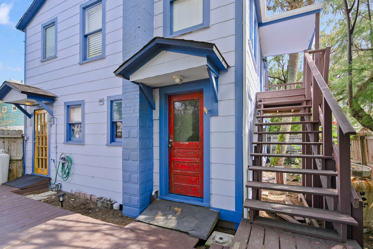 The front of the building, with the exterior staircase serving the upstairs apartment. Your own entrance to Unit A is on the ground floor, so there are no steps to manage with the luggage or the shopping.