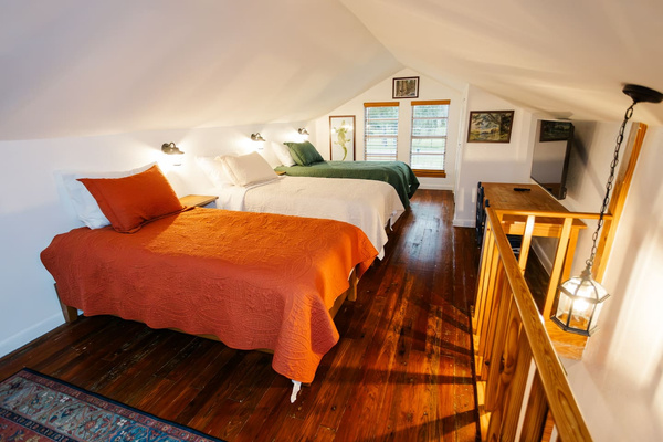 Bright windows fill the loft with natural light, a desk nook, and a TV - room to work or unwind.