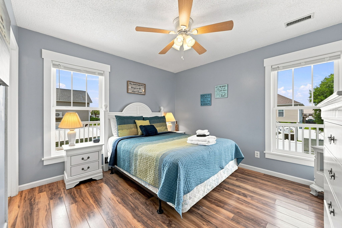 Drift off in this inviting bedroom featuring coastal touches, abundant natural light, and plenty of space to unpack and unwind