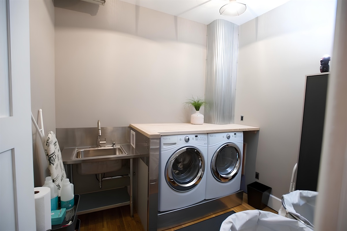 Laundry area includes separate washer and dryer, sink and other cleaning items