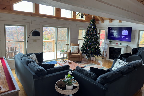 Bright family room with amazing mountain views, fireplace, Shuffleboard Table, and massage chair!  Two large couches that will seat your whole group!